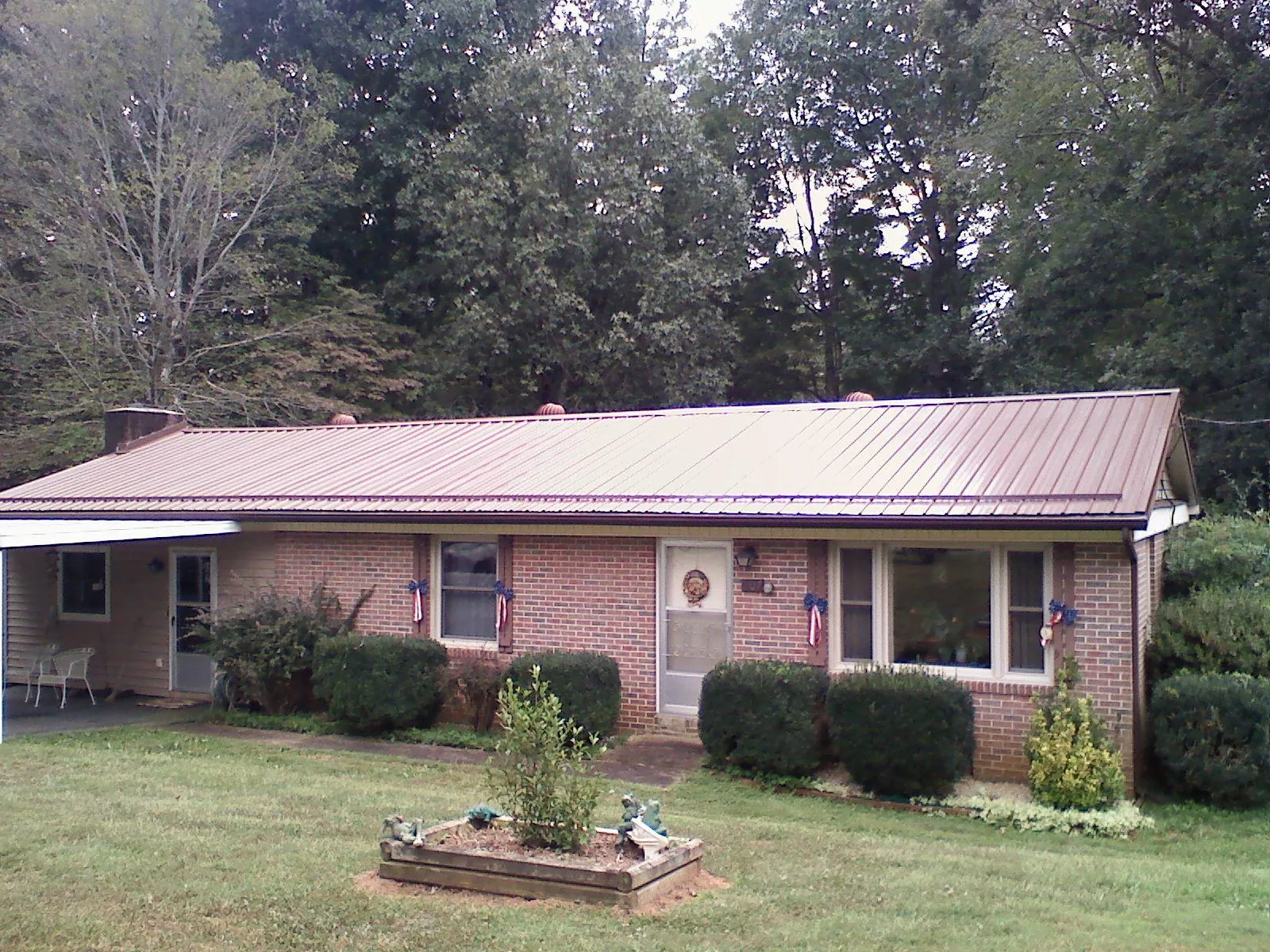 Bronze metal roof on a brick ranch home with a carport in Hobart